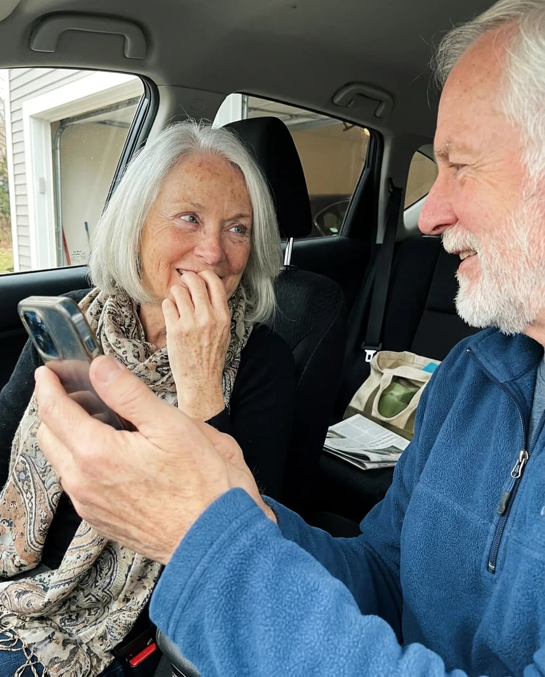 An older woman listening as her husband plays a song from his phone.